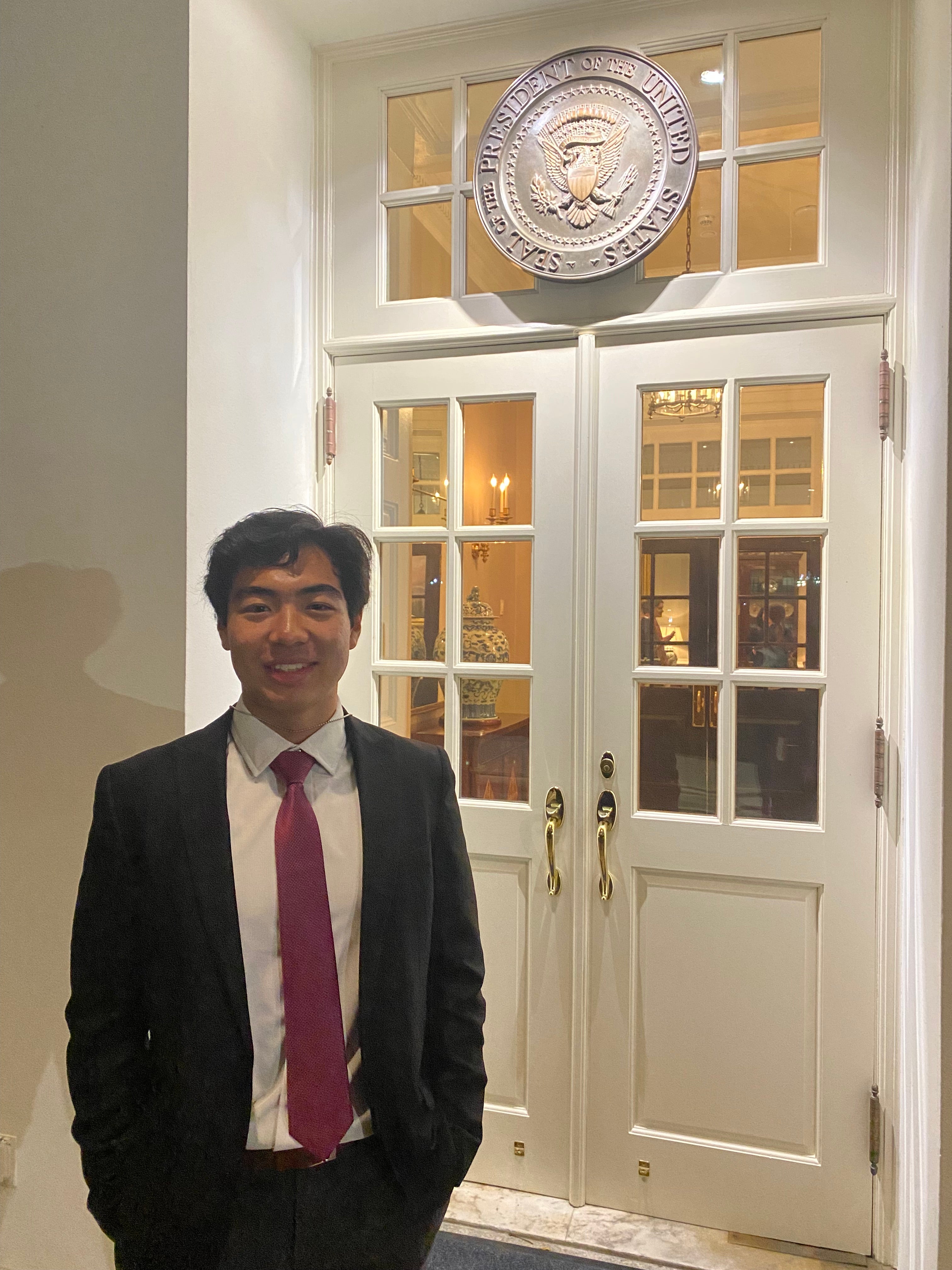 Andrew Park stands in front of the presidential seal in the White House corridor.