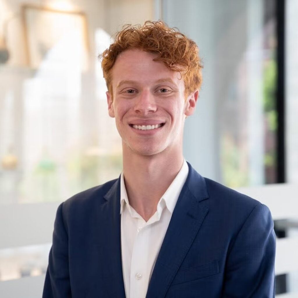 Benjamin Freedman wearing a blue blazer and white button-down shirt.