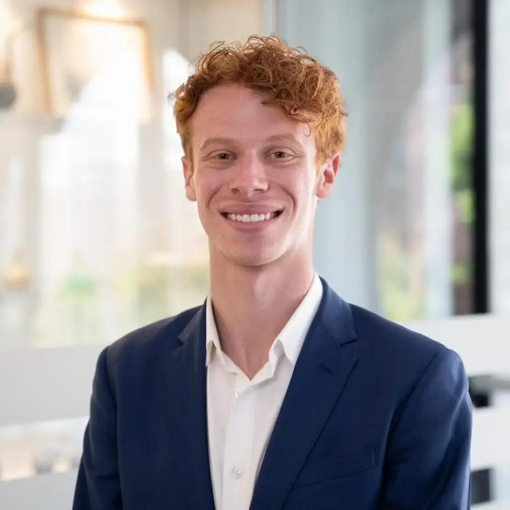 Benjamin Freedman wearing a blue blazer and white button-down shirt.