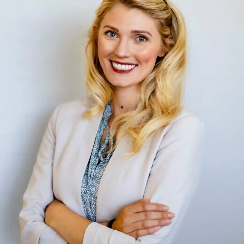 Brecken Costley wearing a cream-colored blazer, and blue and white patterned blouse.