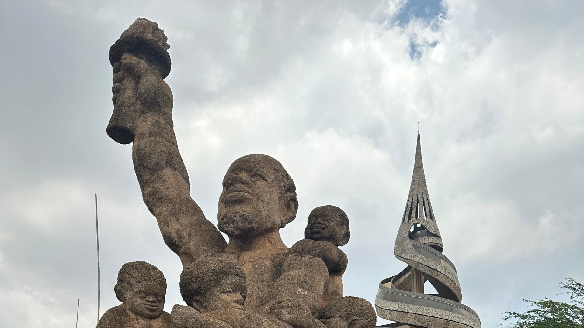 Ben Oestericher and another man stand in front of the Reunification Monument in Cameroon.