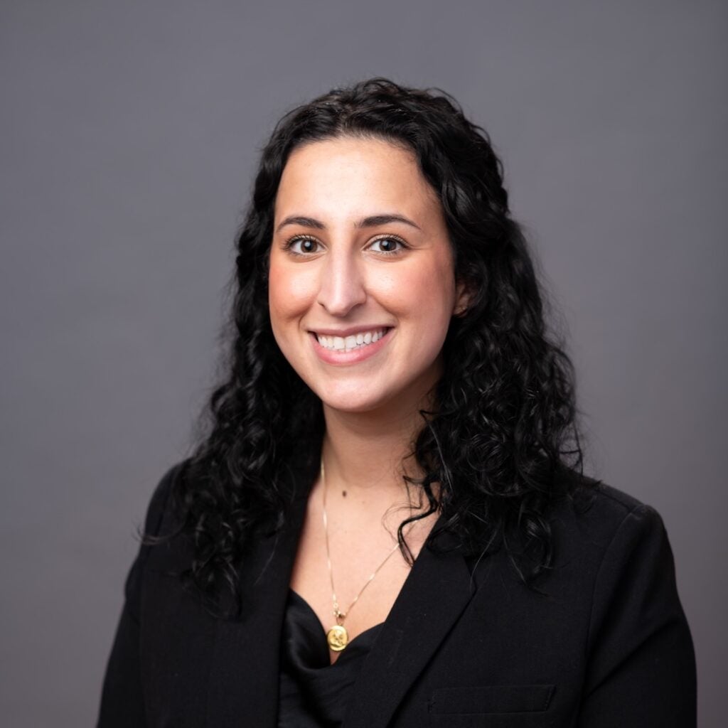 Careena Manoukian wearing a black shirt and a gold necklace.