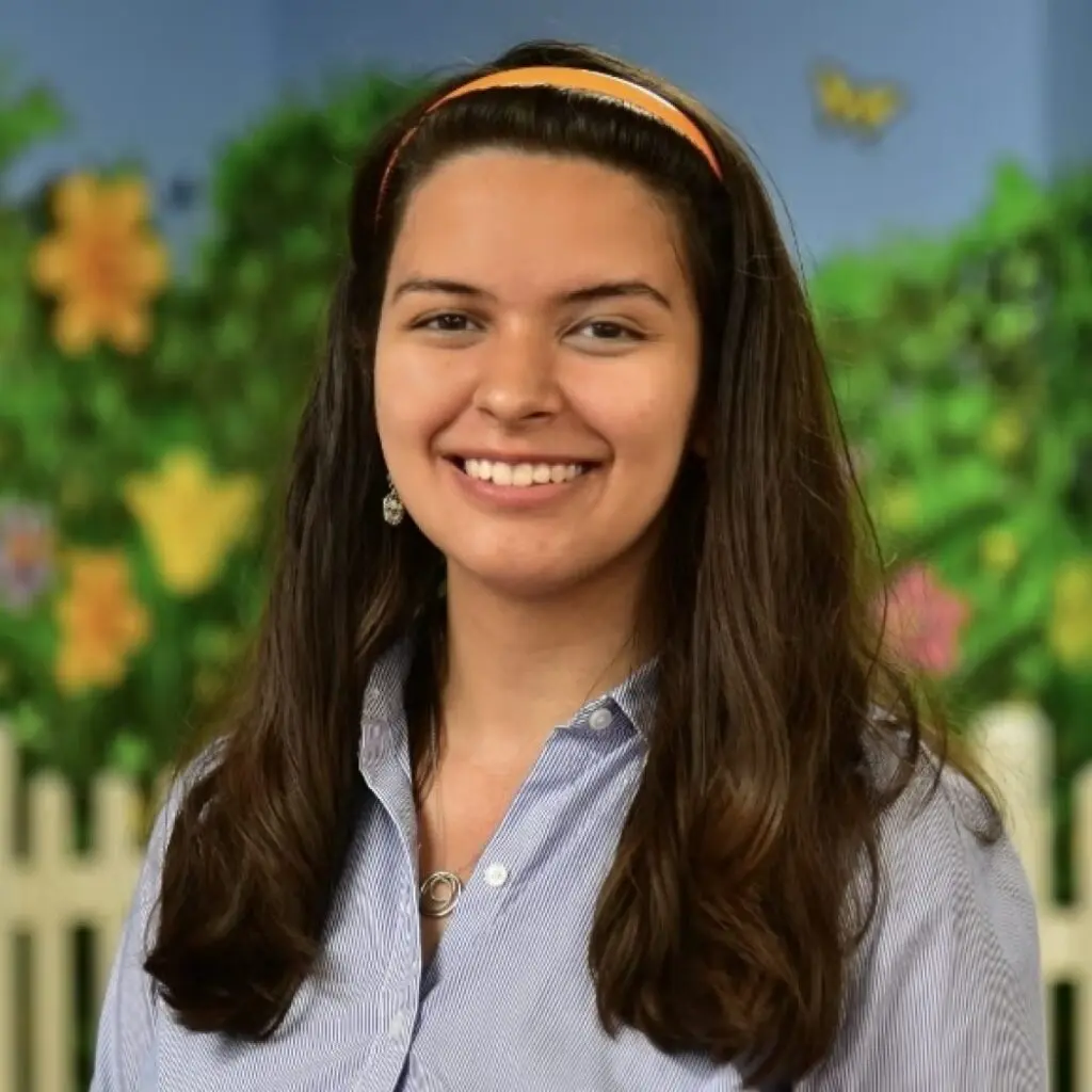 Christina Prinssen wearing an orange headband and blue button-down shirt.