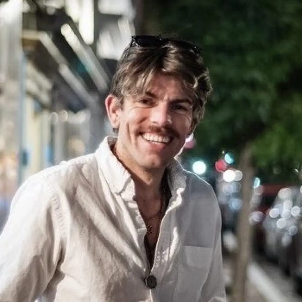 Conor McWeeney wearing a white button-down shirt.