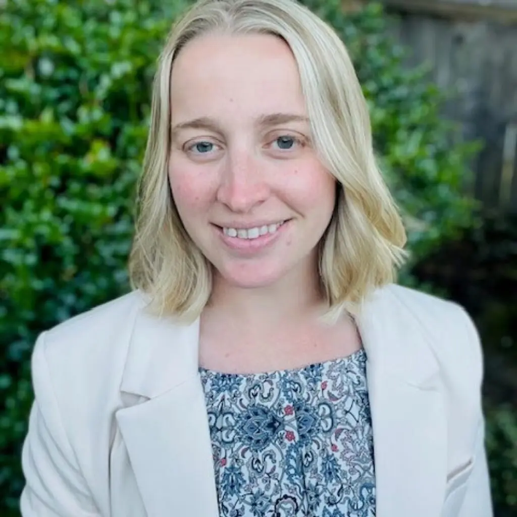 Courtney Totorica wearing a white blazer with floral blouse.
