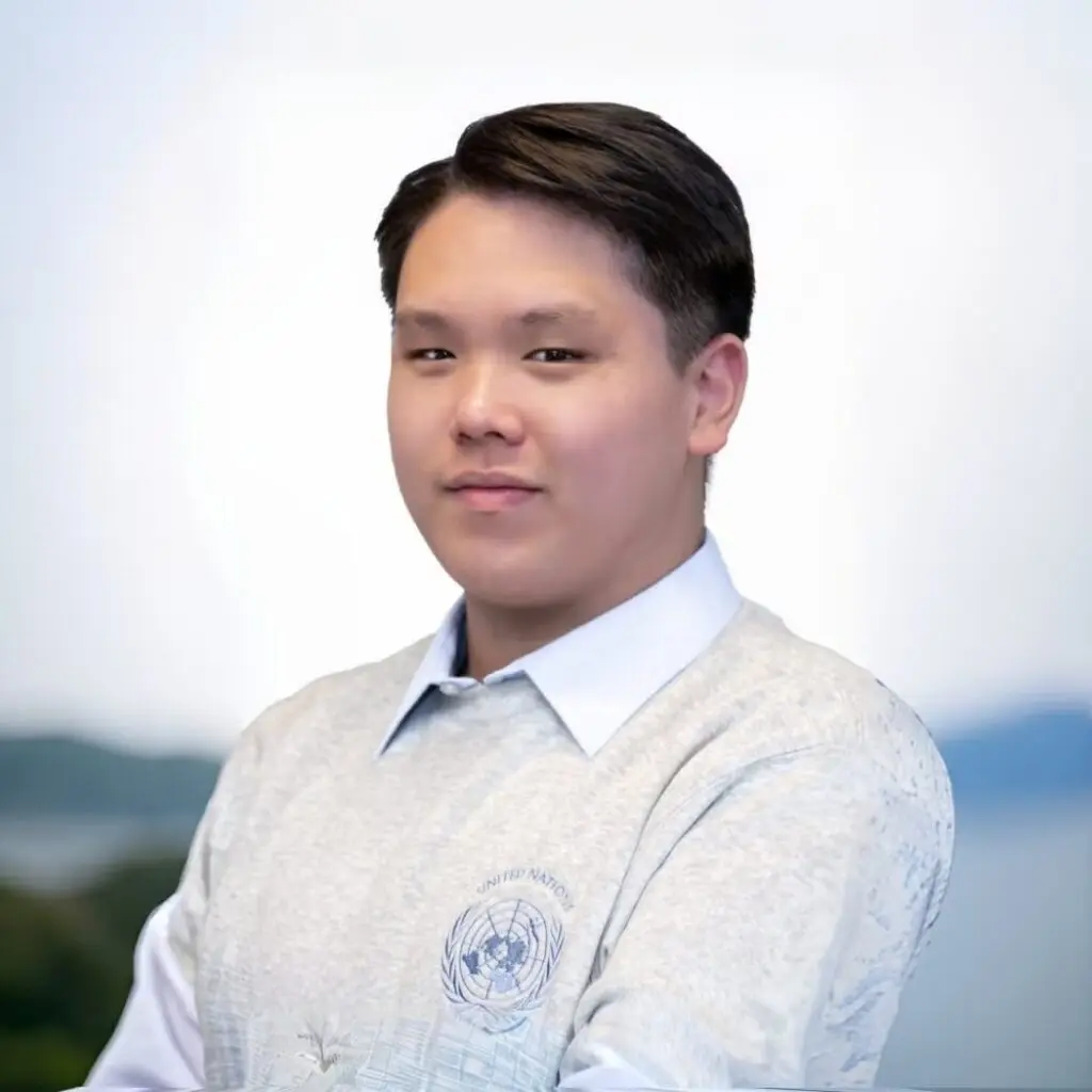 David Chu wearing a gray T-shirt over a white button-down shirt.