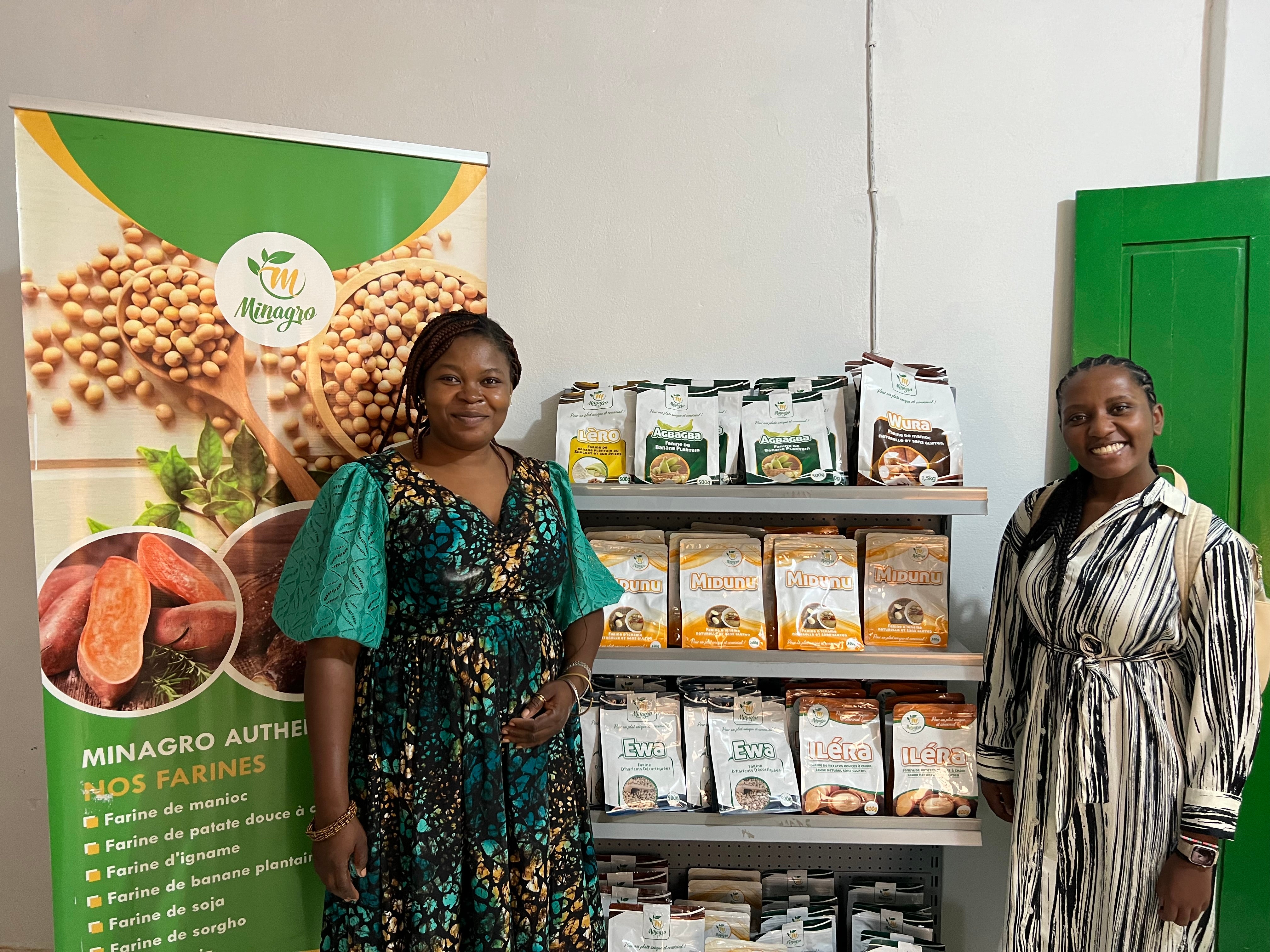 Two individuals standing beside a product display, smiling. The display features various packaged food products.