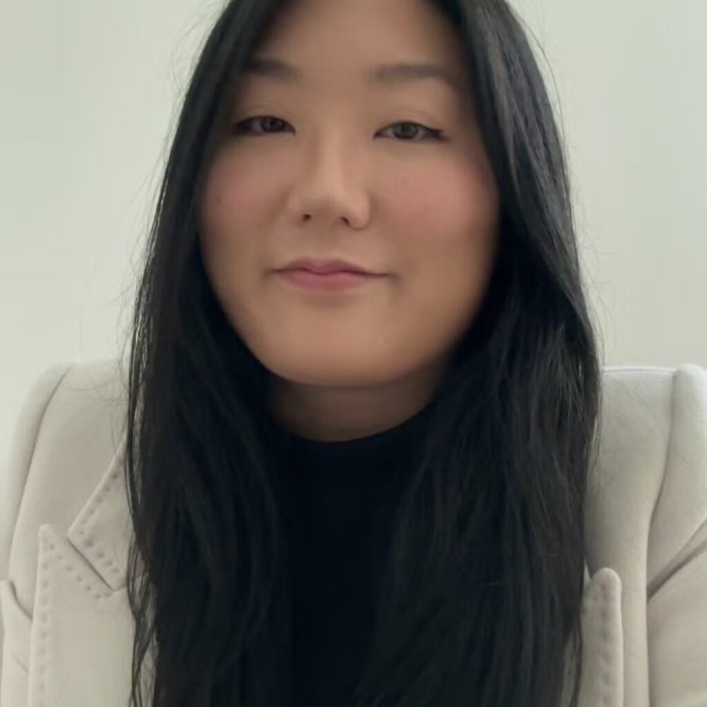 Doria Kim wearing a black shirt and a cream blazer.