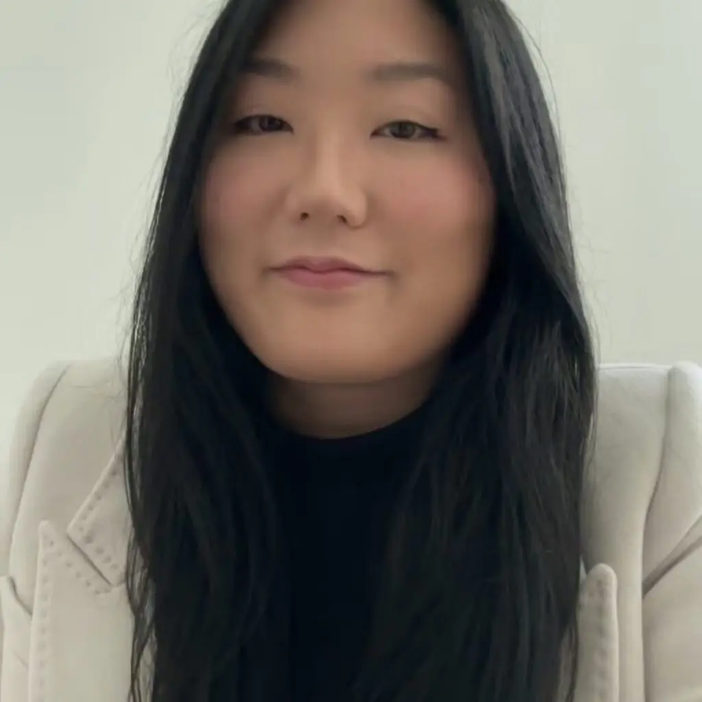 Doria Kim wearing a black shirt and a cream blazer.