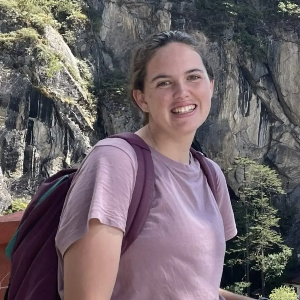 Eileen O'Connor wearing a light purple T-shirt, and carrying a backpack.
