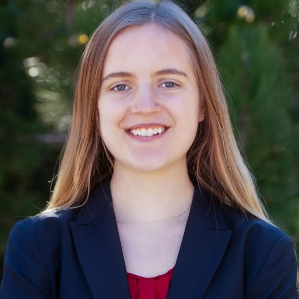 Elizabeth Koenck wearing a navy blue blazer and a red shirt.
