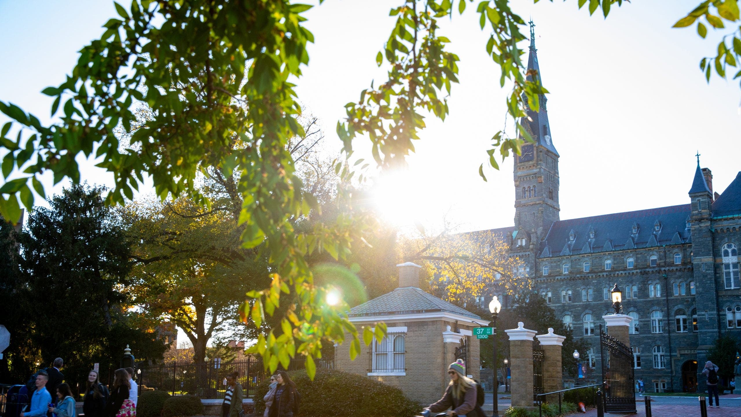 Campus entrance on O street in the morning sunshine. Students are walking close to the entrance.