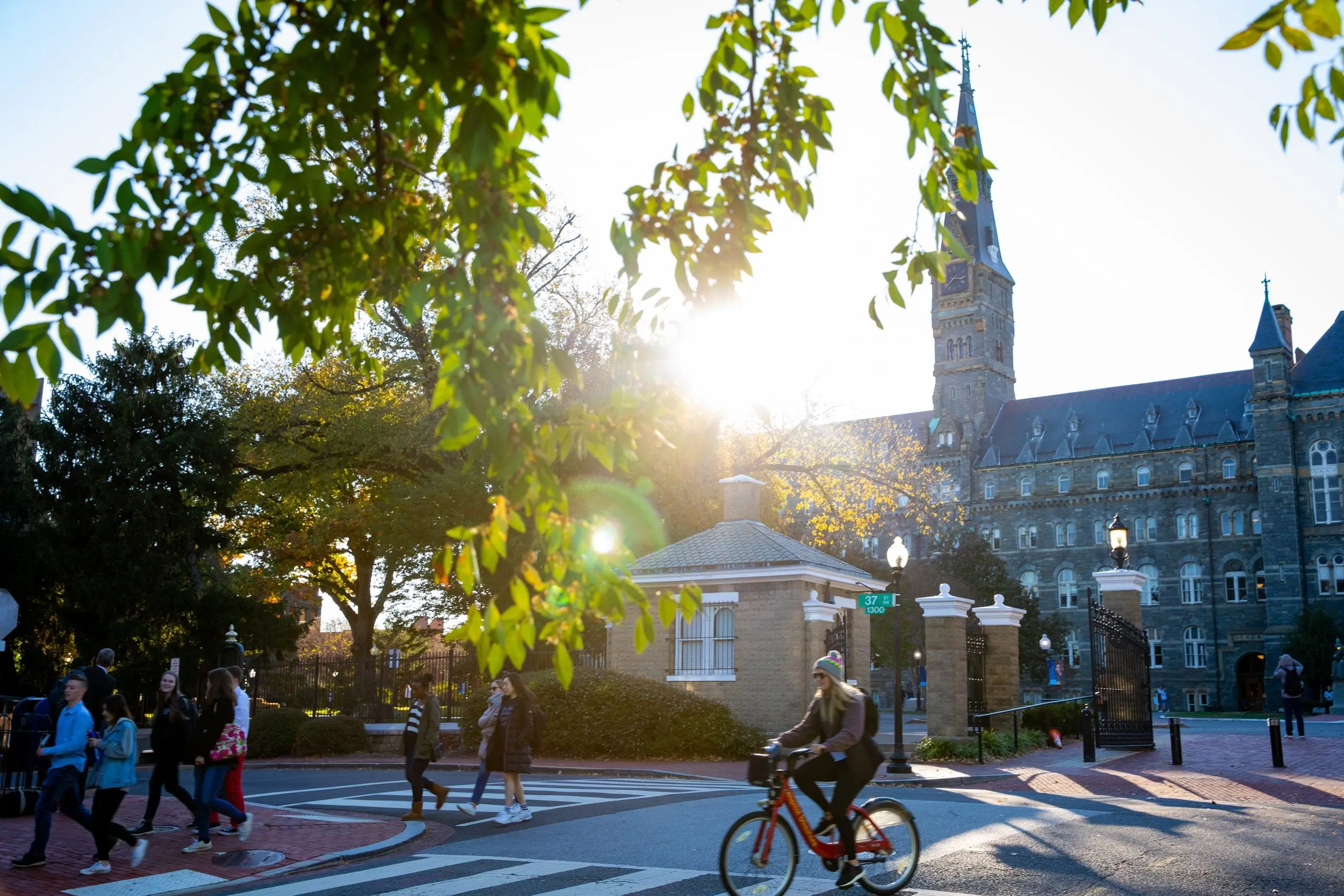Campus entrance on O street in the morning sunshine. Students are walking close to the entrance.