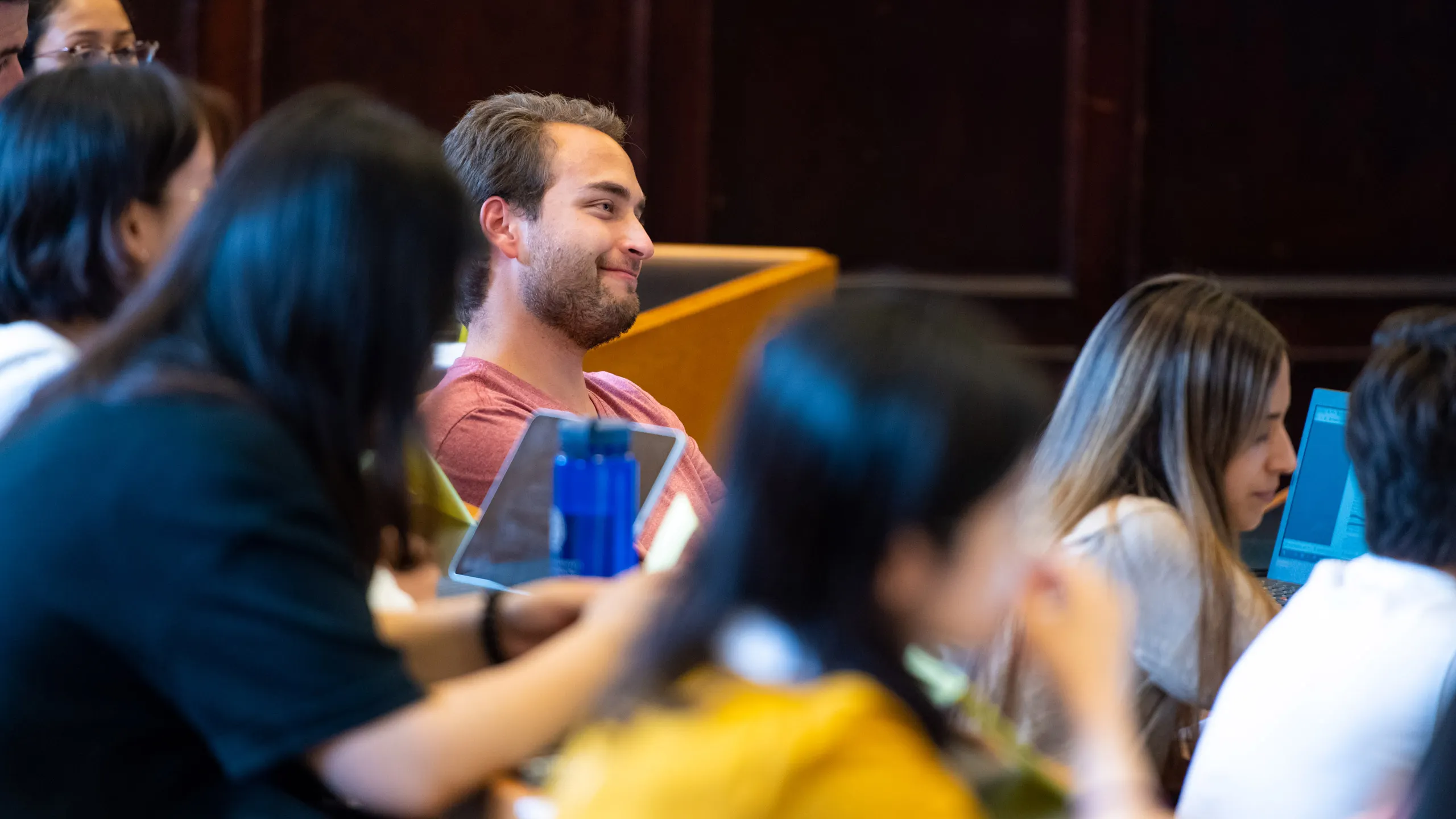 students sitting in a classroom, smiling.