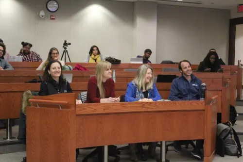 Four students sit together inside the Beeck Center. Left to right, there are three women and one man.