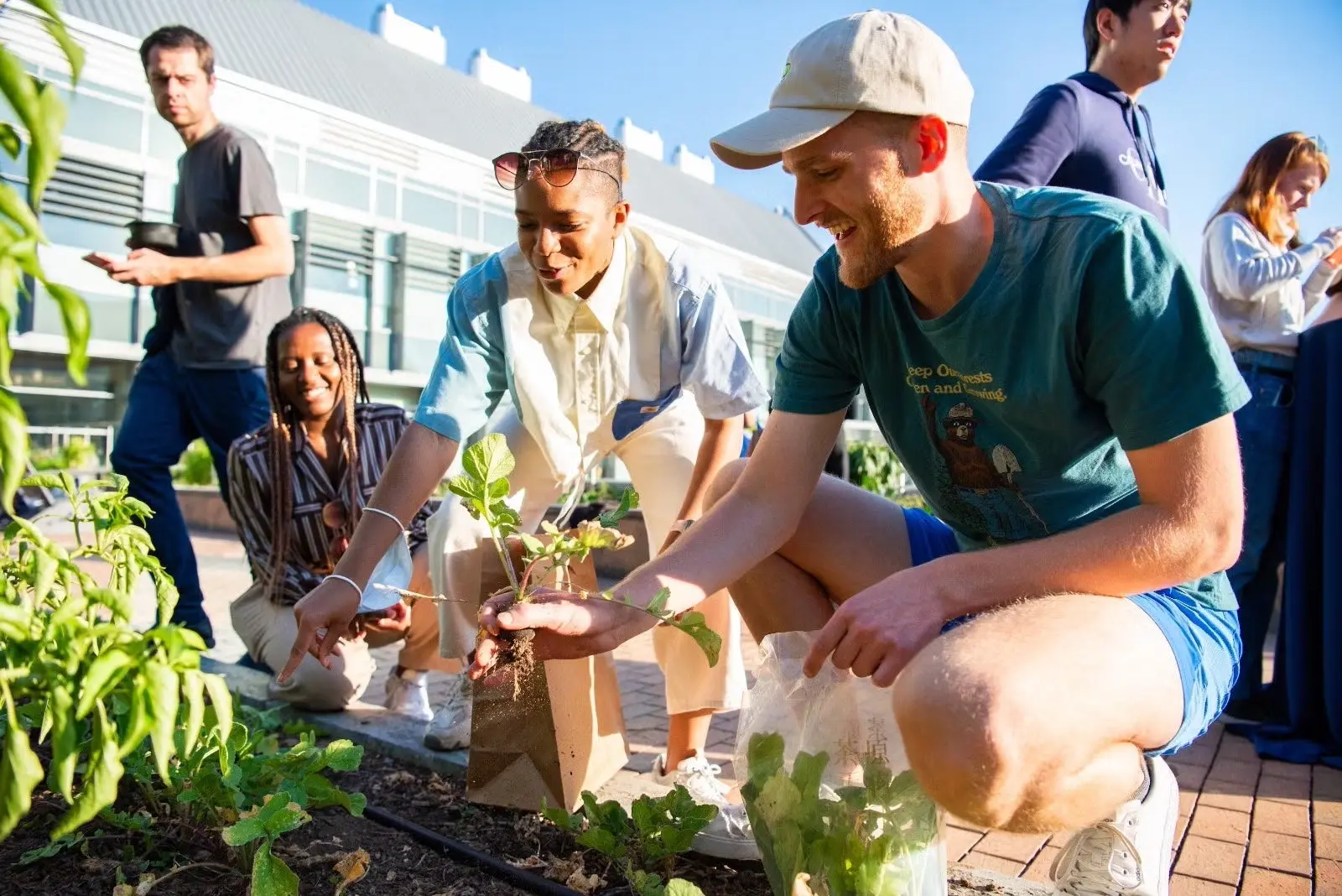 GHD students Kyla Denwood, Kennedy Copeland, and Richard Newsome (all GHD'25) plant in the garden at Georgetown.