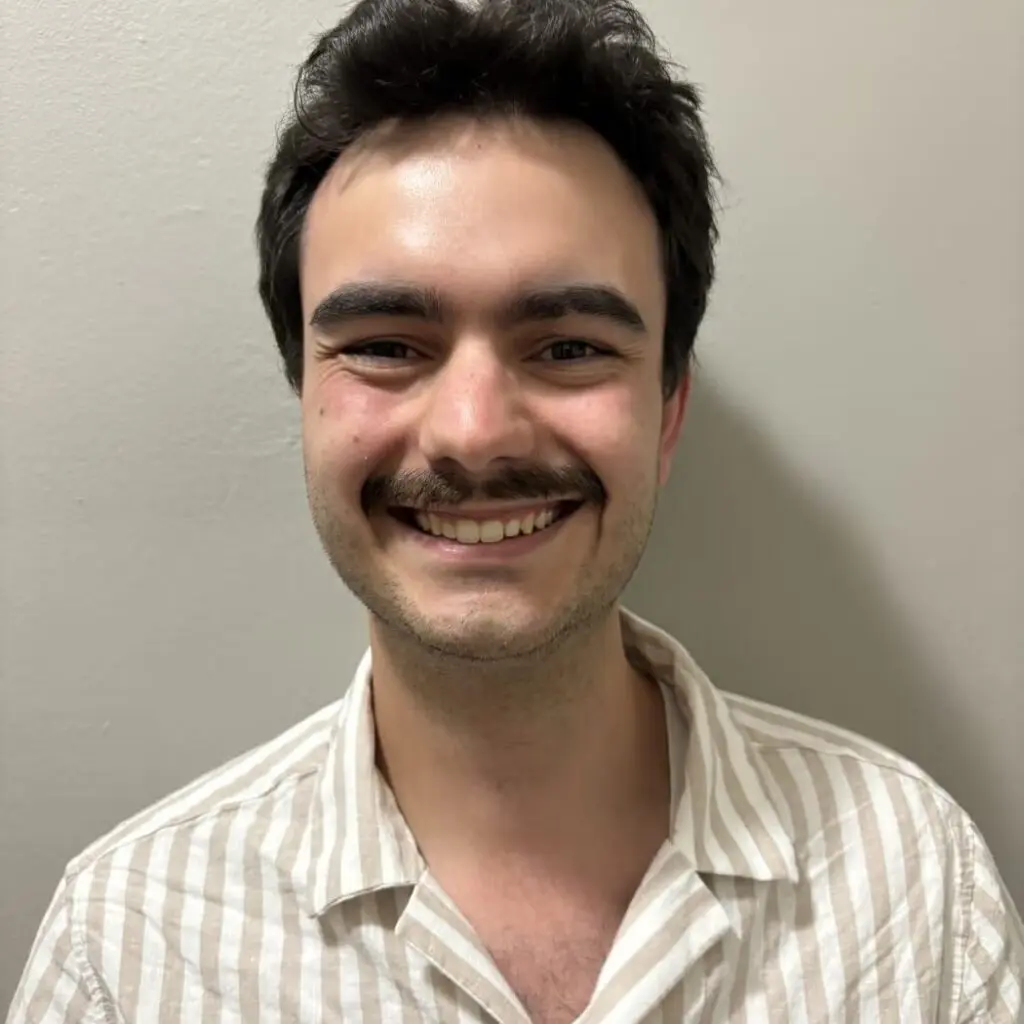 Gabriel Cabanas wearing a tan and white striped button-down shirt.