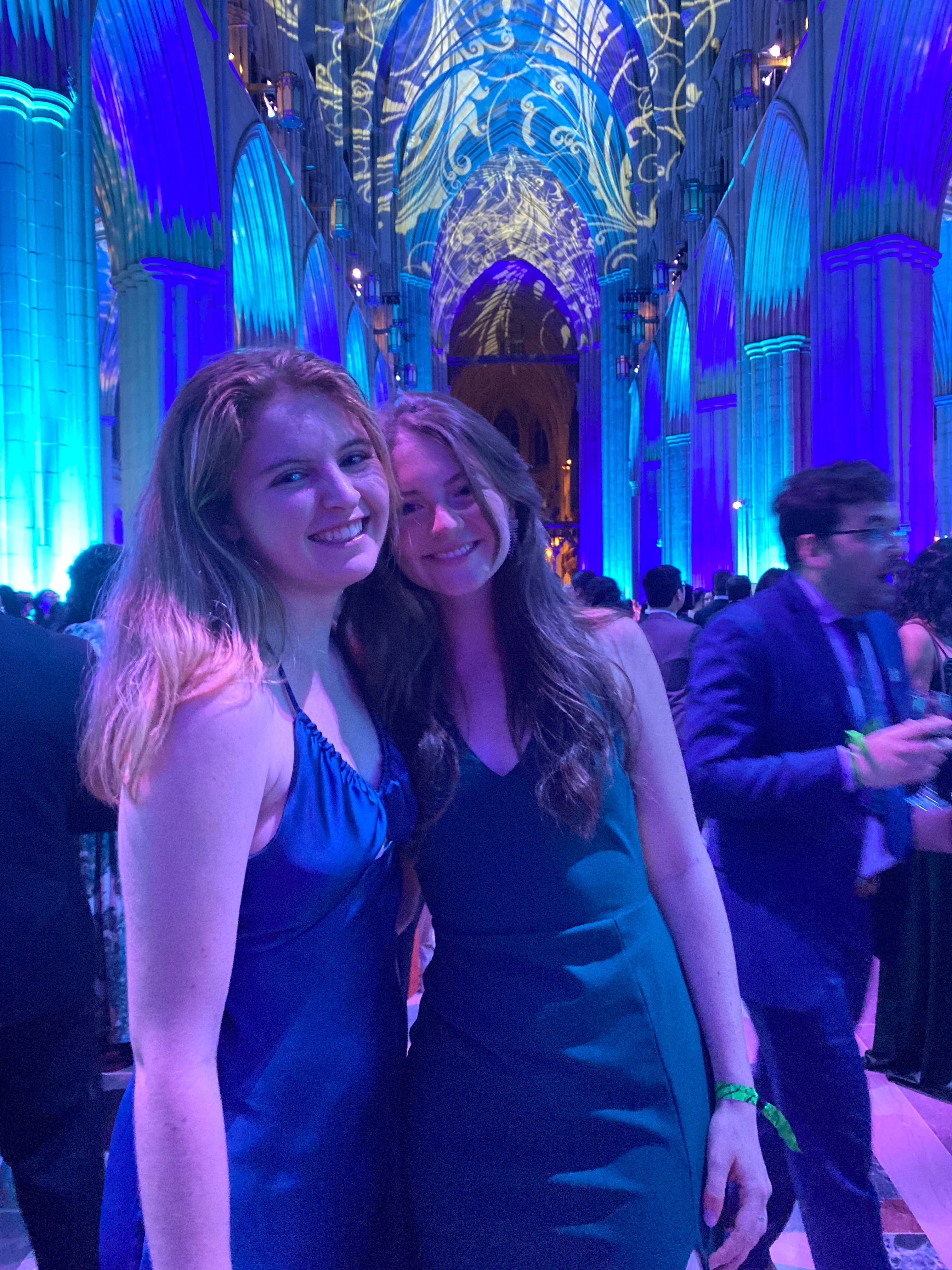 Georgie Wilson and her friend stand with their arms around each other wearing evening attire.