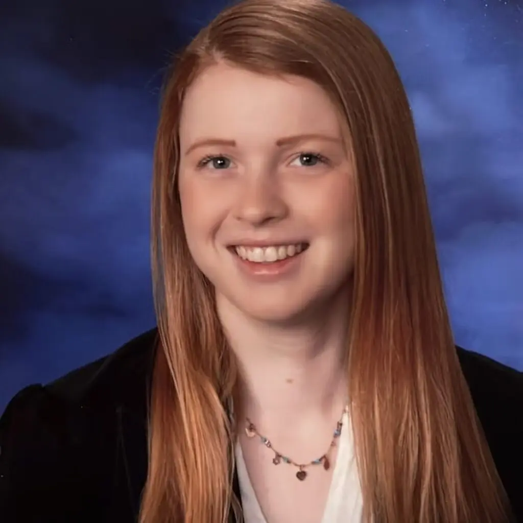 Hannah Bair wearing a black blazer and a white button-down shirt.