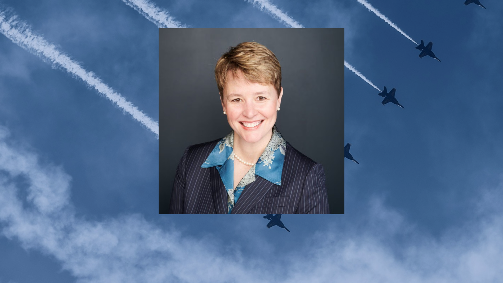 Heidi Urben headshot in front of military planes in formation in the sky.