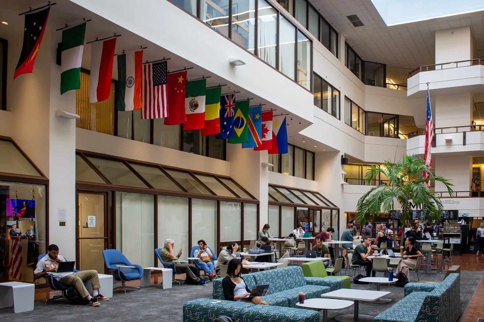 SFS students sitting in the ICC atrium with world flags above them