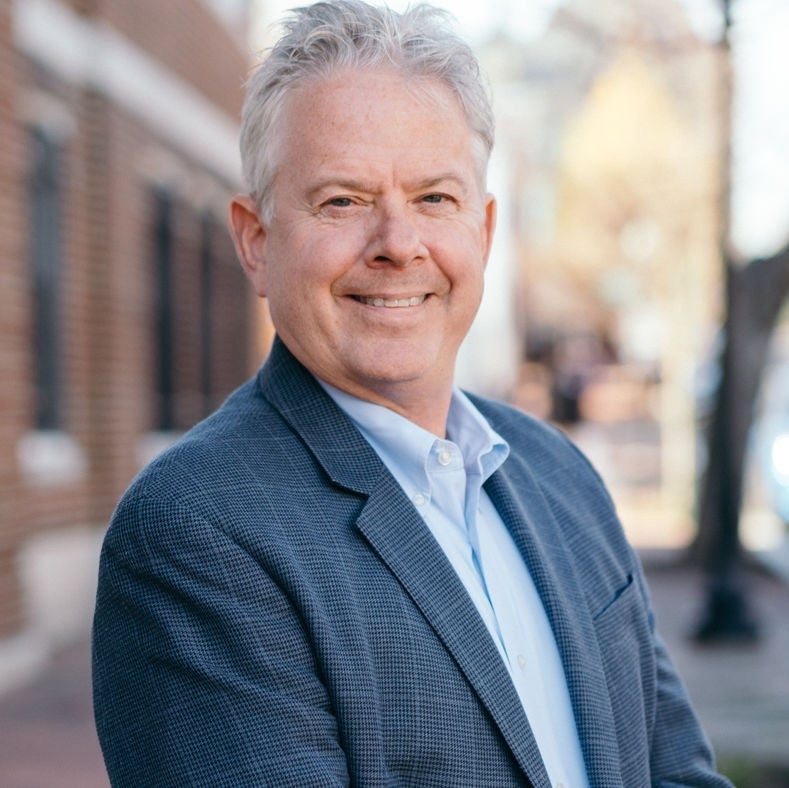 Jeffrey Anderson wearing a blue blazer and a button down shirt.