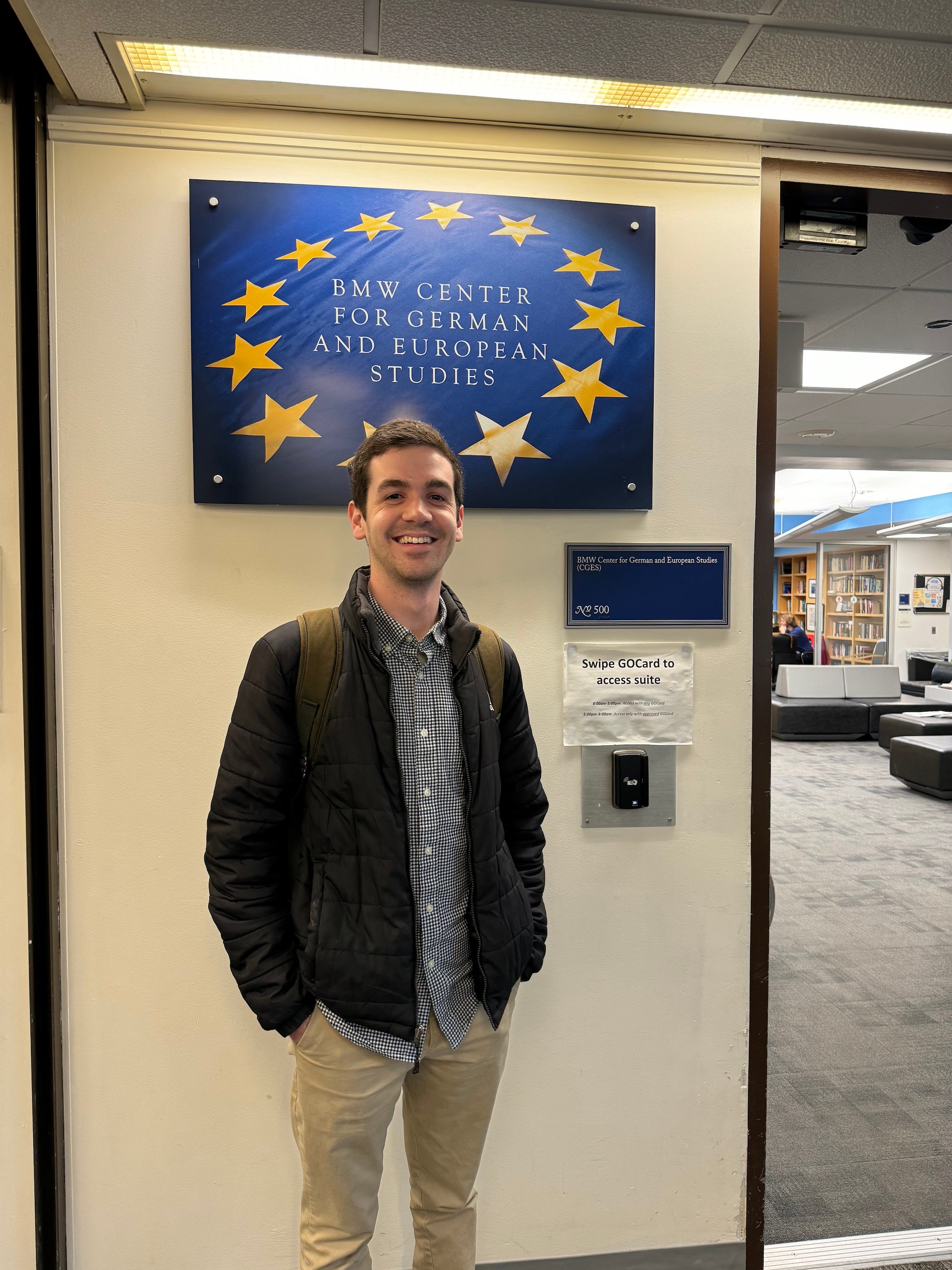 Joe Locher stands in front of the BMW Center for German and European Studies sign in ICC.