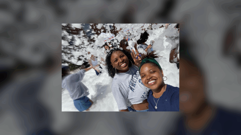 Two individuals with joyful expressions participating in a snowball fight.
