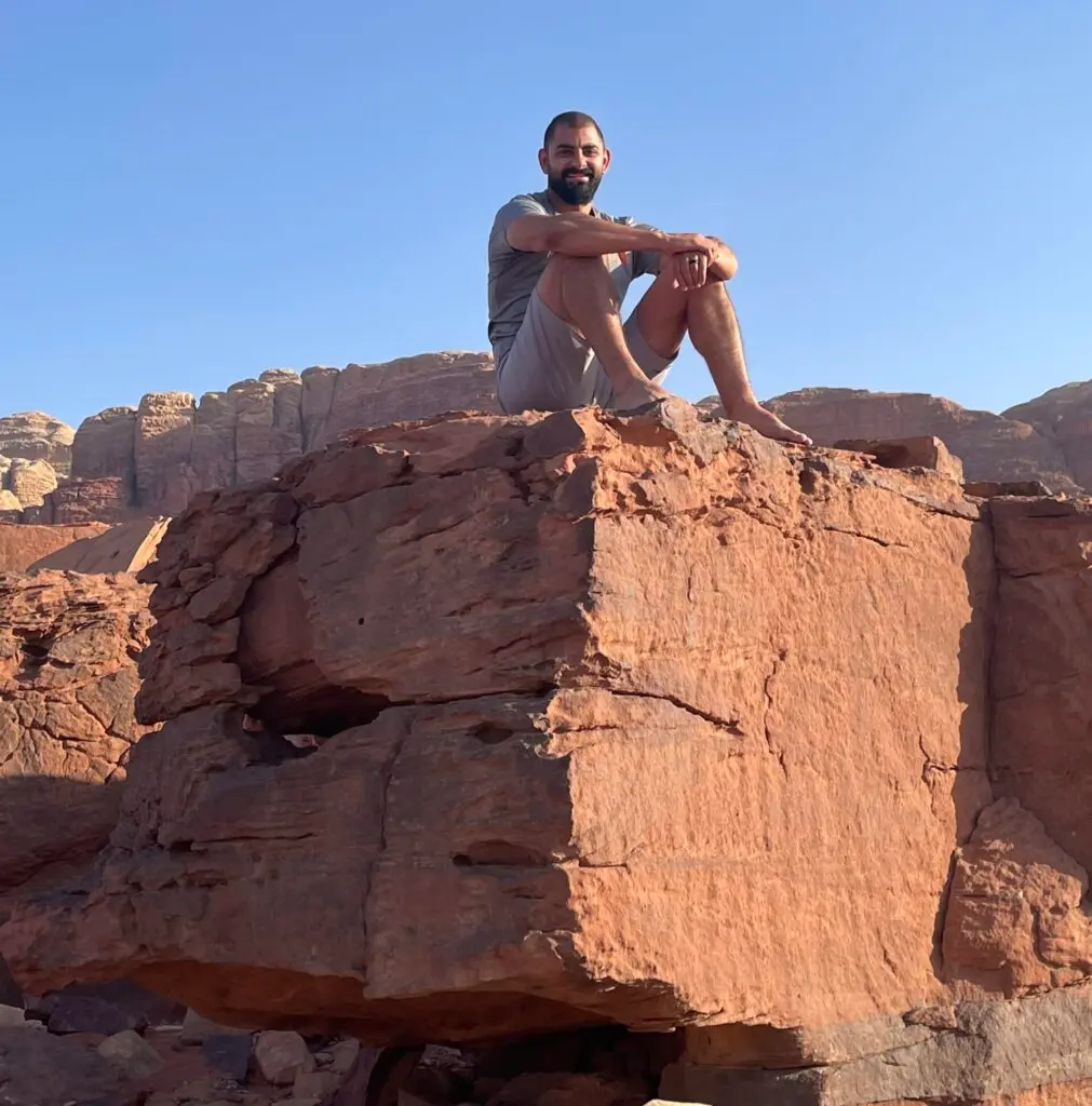John Korban sits on a cliff in Wadi Rum, Jordan.