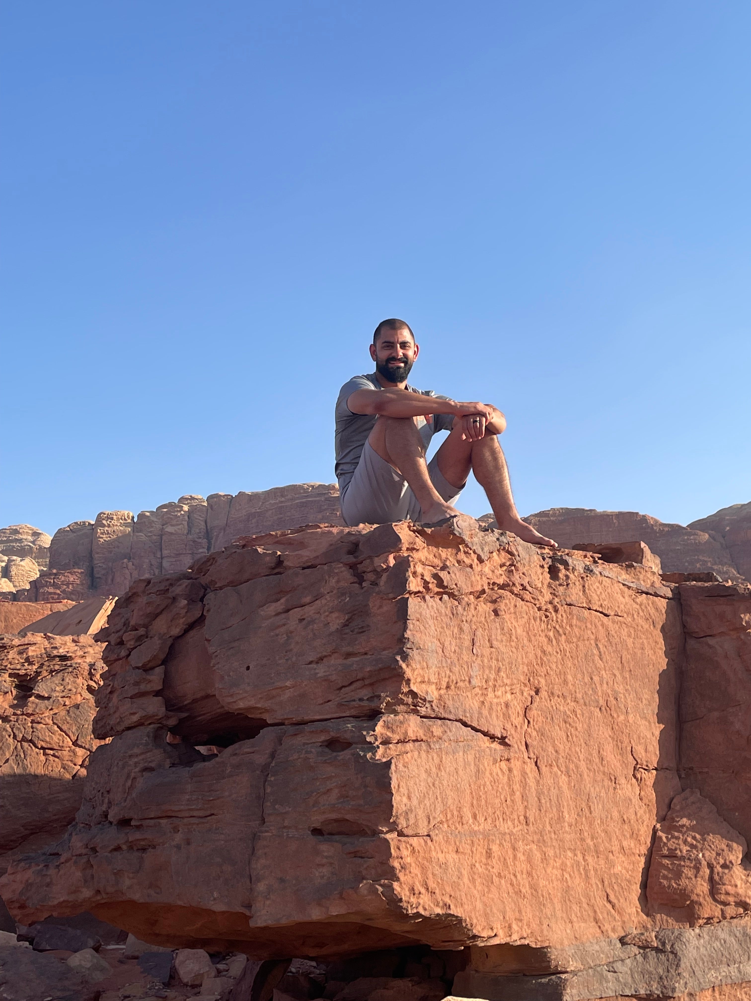 John Korban sits on a cliff in Wadi Rum, Jordan.