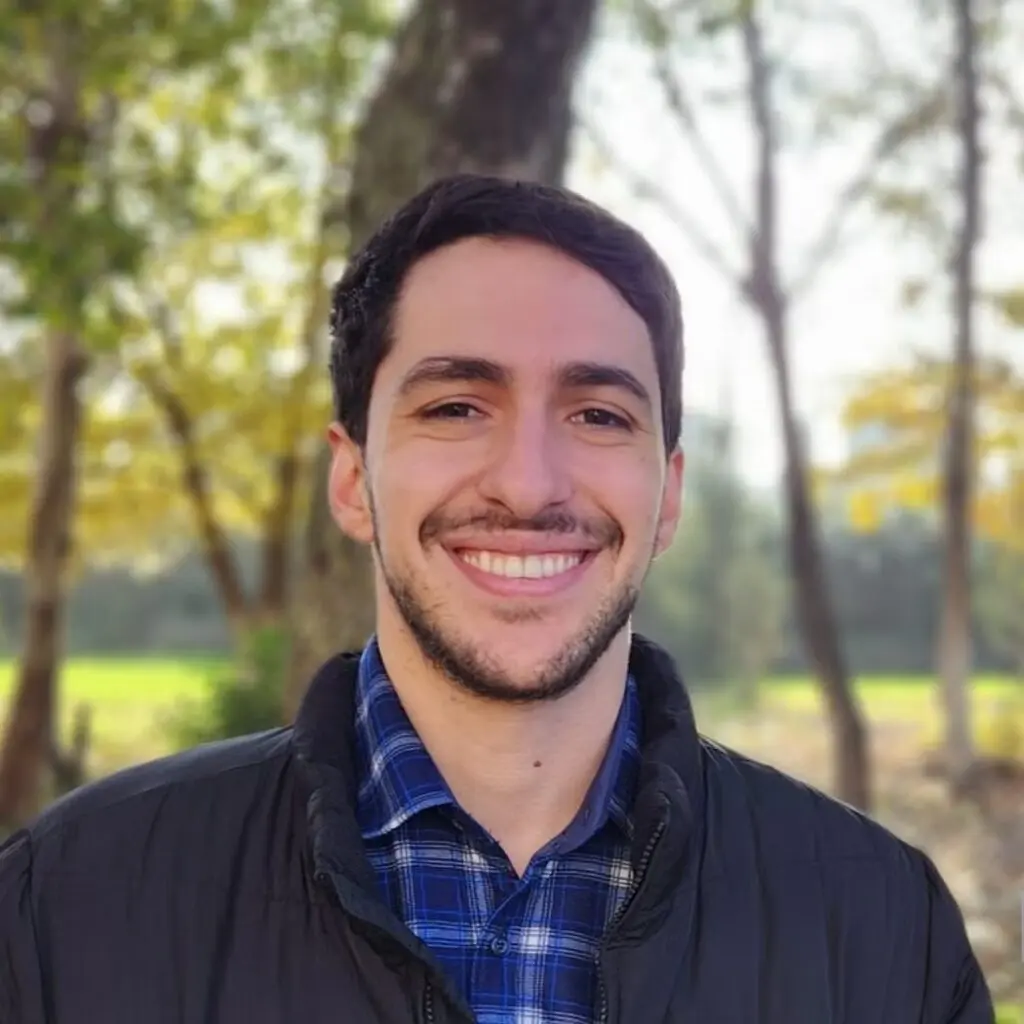 Joshua Elias wearing a black jacket and blue plaid shirt.