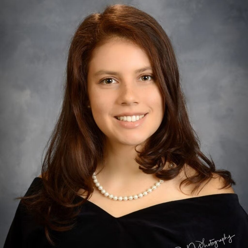 Kylie Hay-Roe wearing a black blouse and pearl necklace.