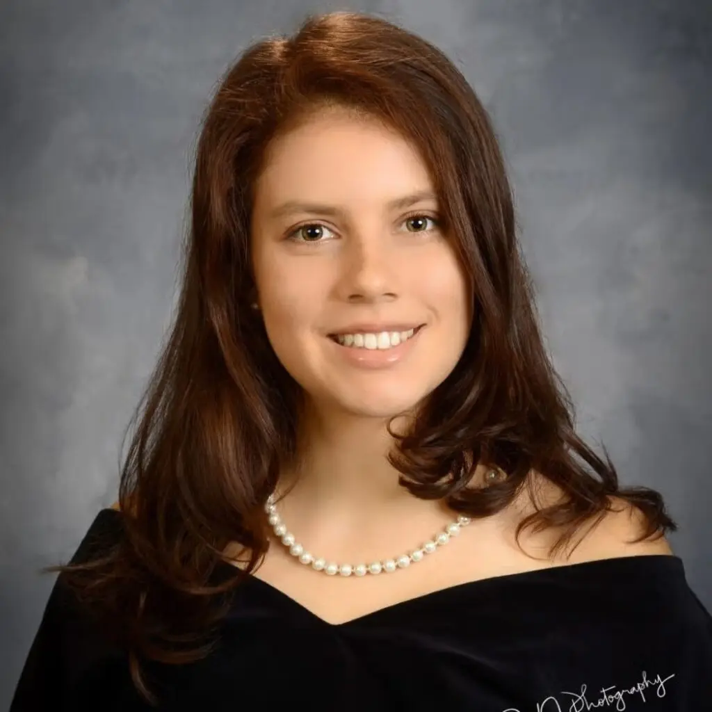 Kylie Hay-Roe wearing a black blouse and pearl necklace.