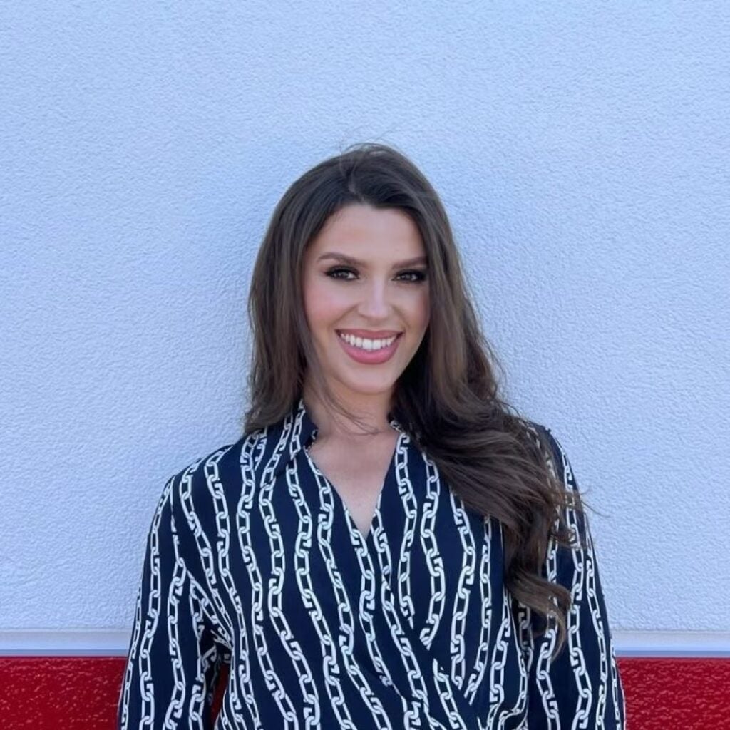 Leona Koxha wearing a dark patterned blouse.