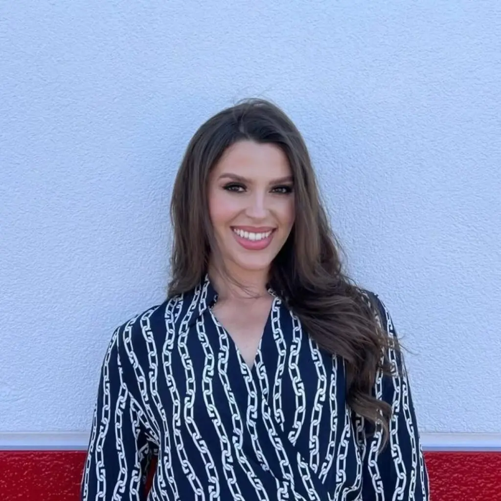 Leona Koxha wearing a dark patterned blouse.