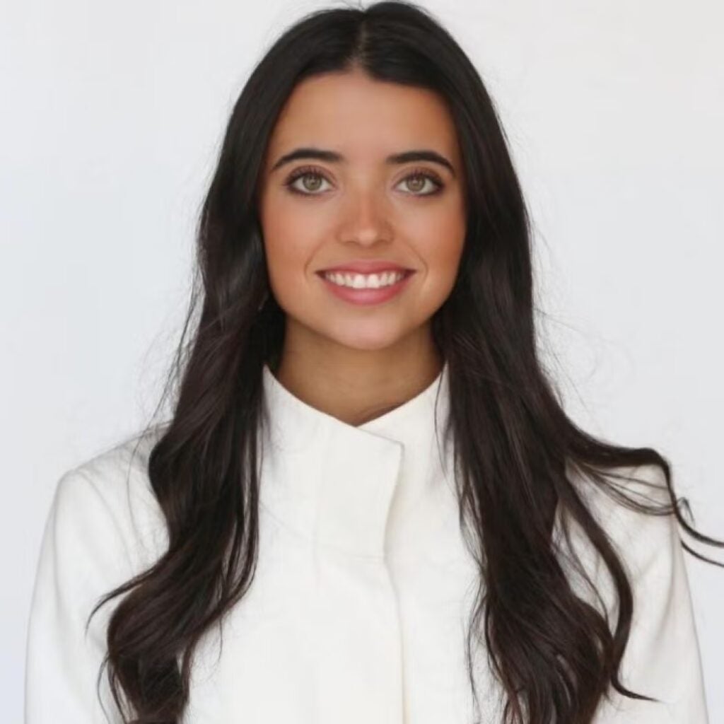 Luciana Dahdah wearing a white blouse and smiling.