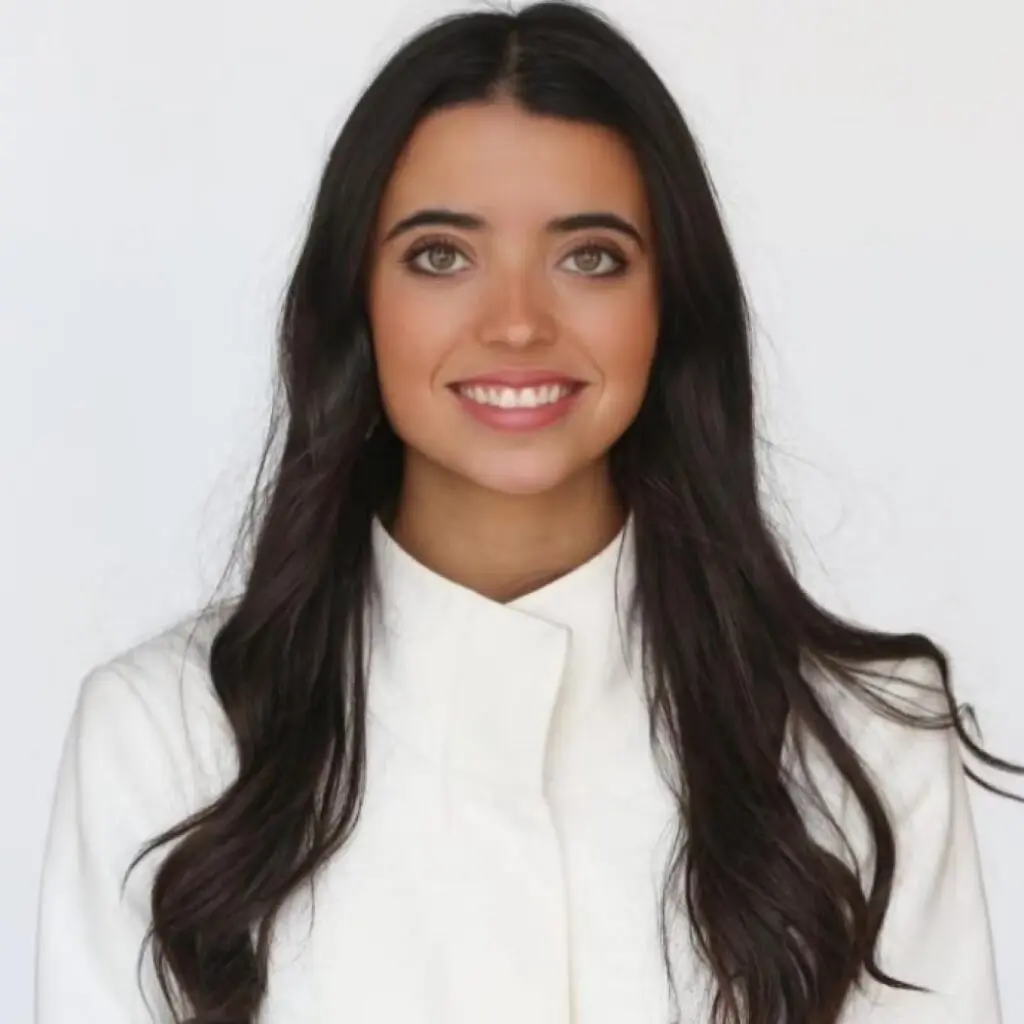 Luciana Dahdah wearing a white blouse and smiling.