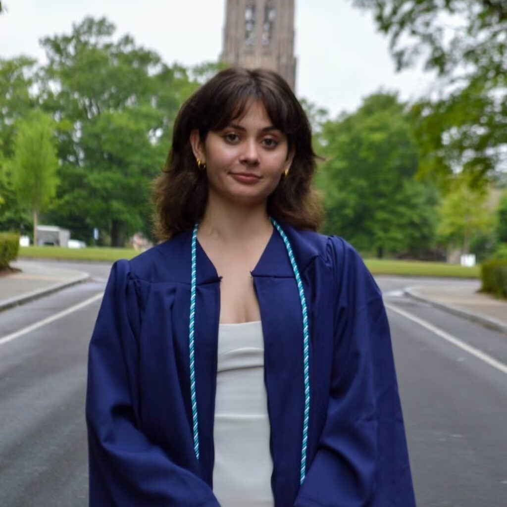 Manon Fuchs in blue graduation regalia.