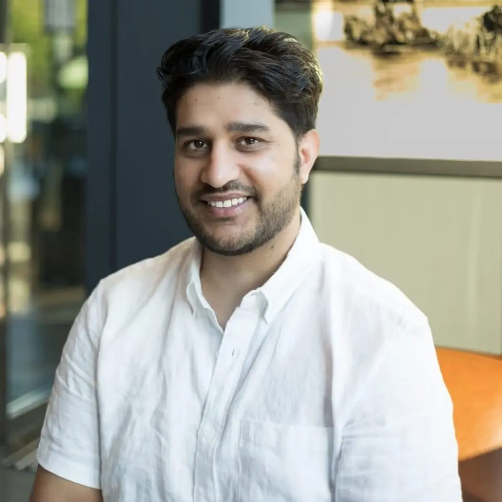 Nabin Dhimal wearing a white button down shirt and smiling