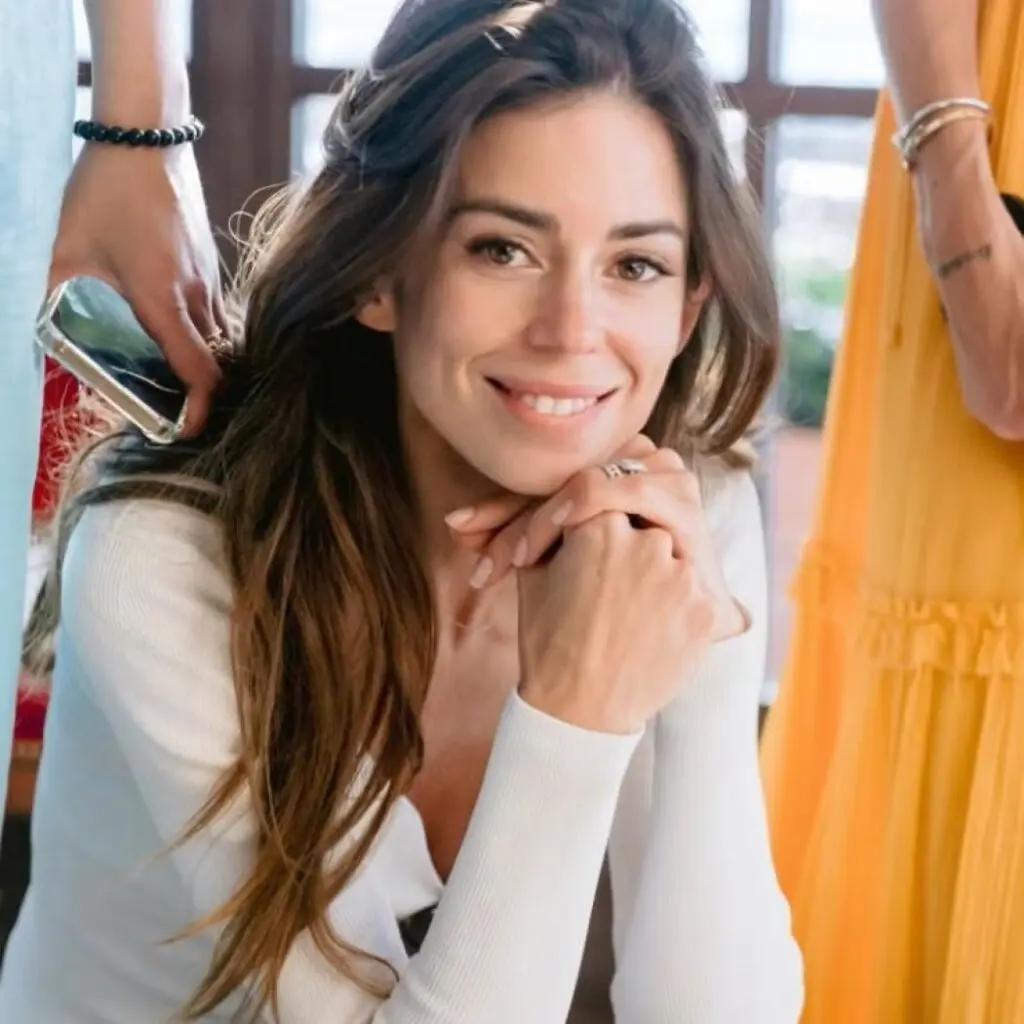 Natali Husic Sarkozy wearing a white cardigan.