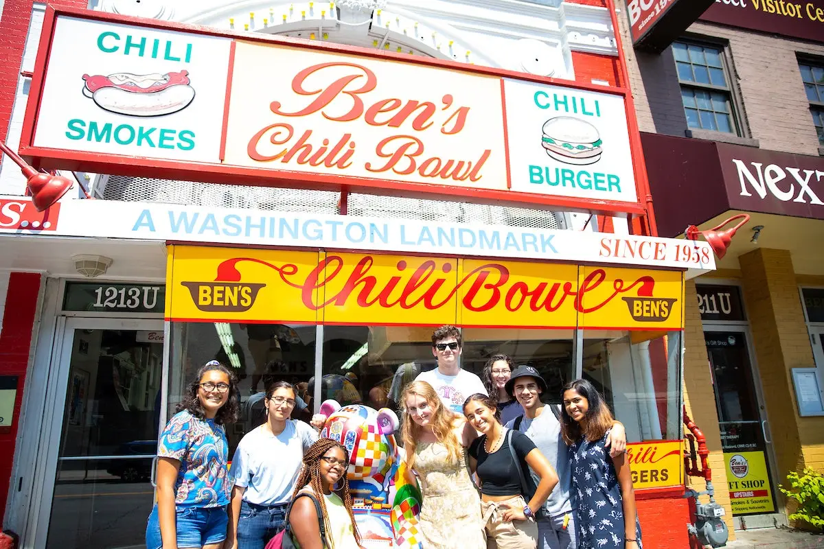 A group of Georgetown students posing in front on Ben's Chili Bowl restaurant.
