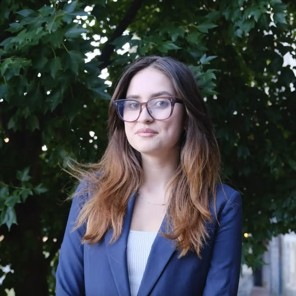 Ophelia Bentley wearing a blue blazer, a white shirt, and glasses.