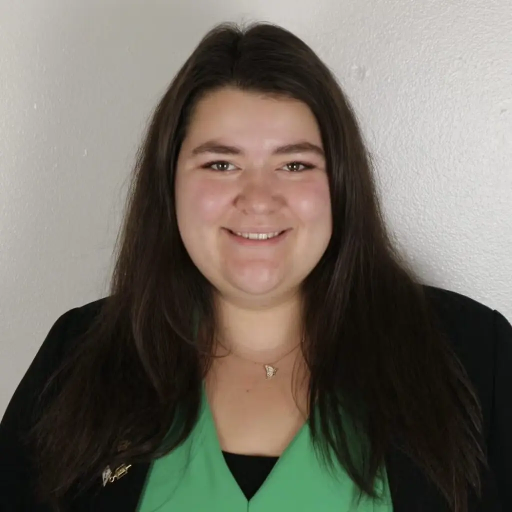 Rachel Kern wearing a green shirt and black blazer.