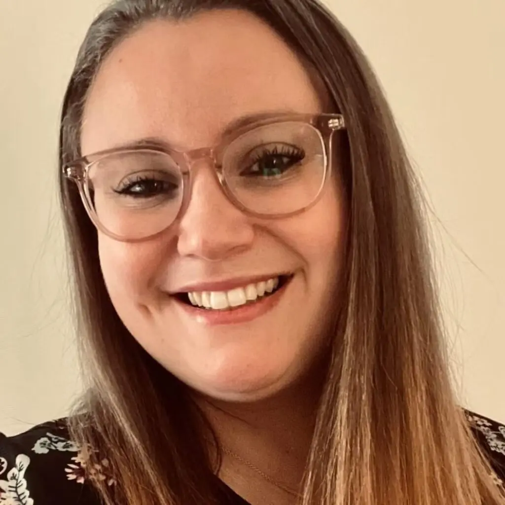 Rebecca Hart wearing a floral blouse and glasses.