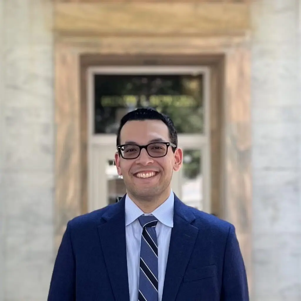 Robert La Terza wearing a navy blue blazer, a light blue, button-down shirt, and a blue striped tie.