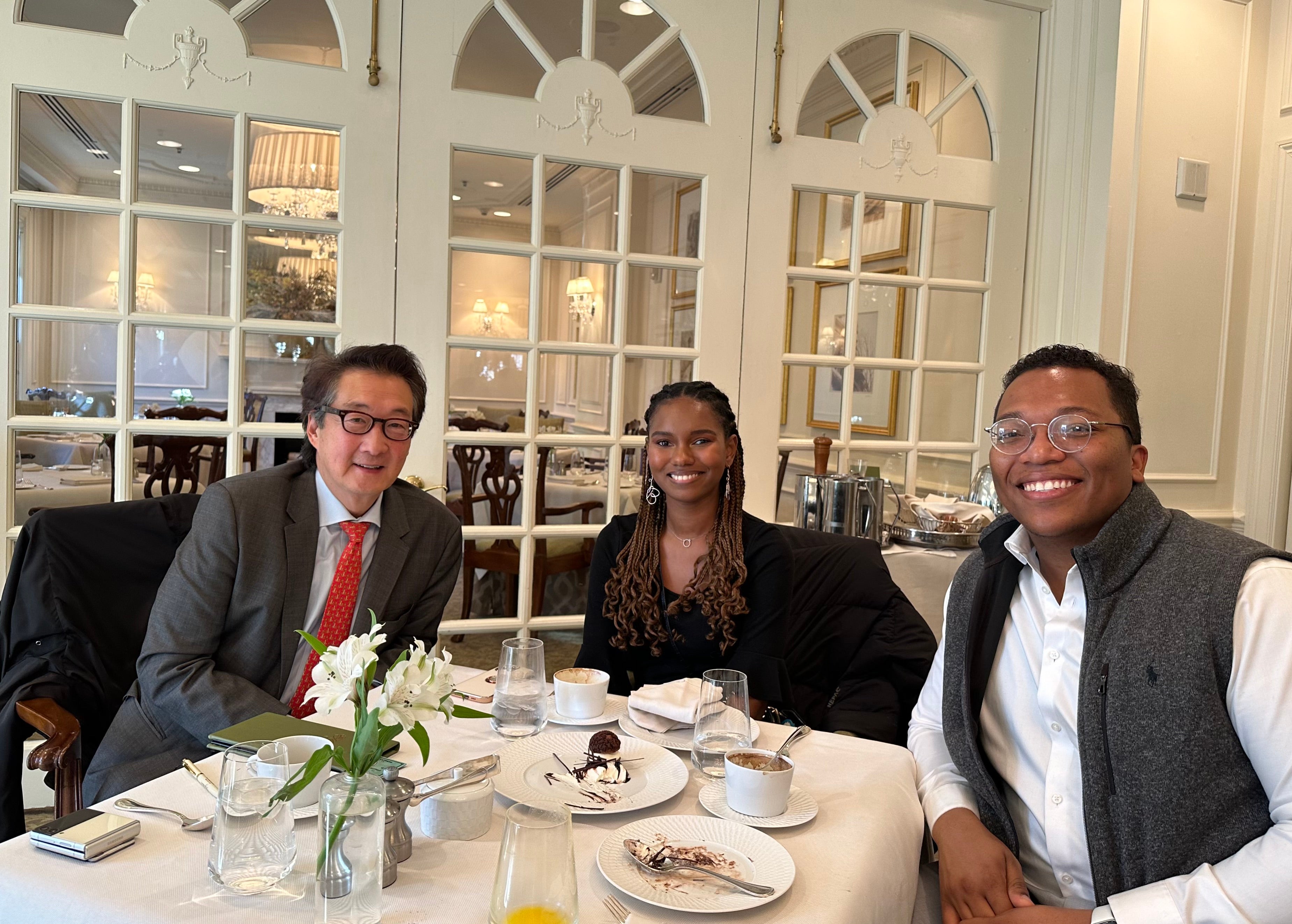Bah and her classmate sit at a table in a restaurant with Professor Victor Cha.