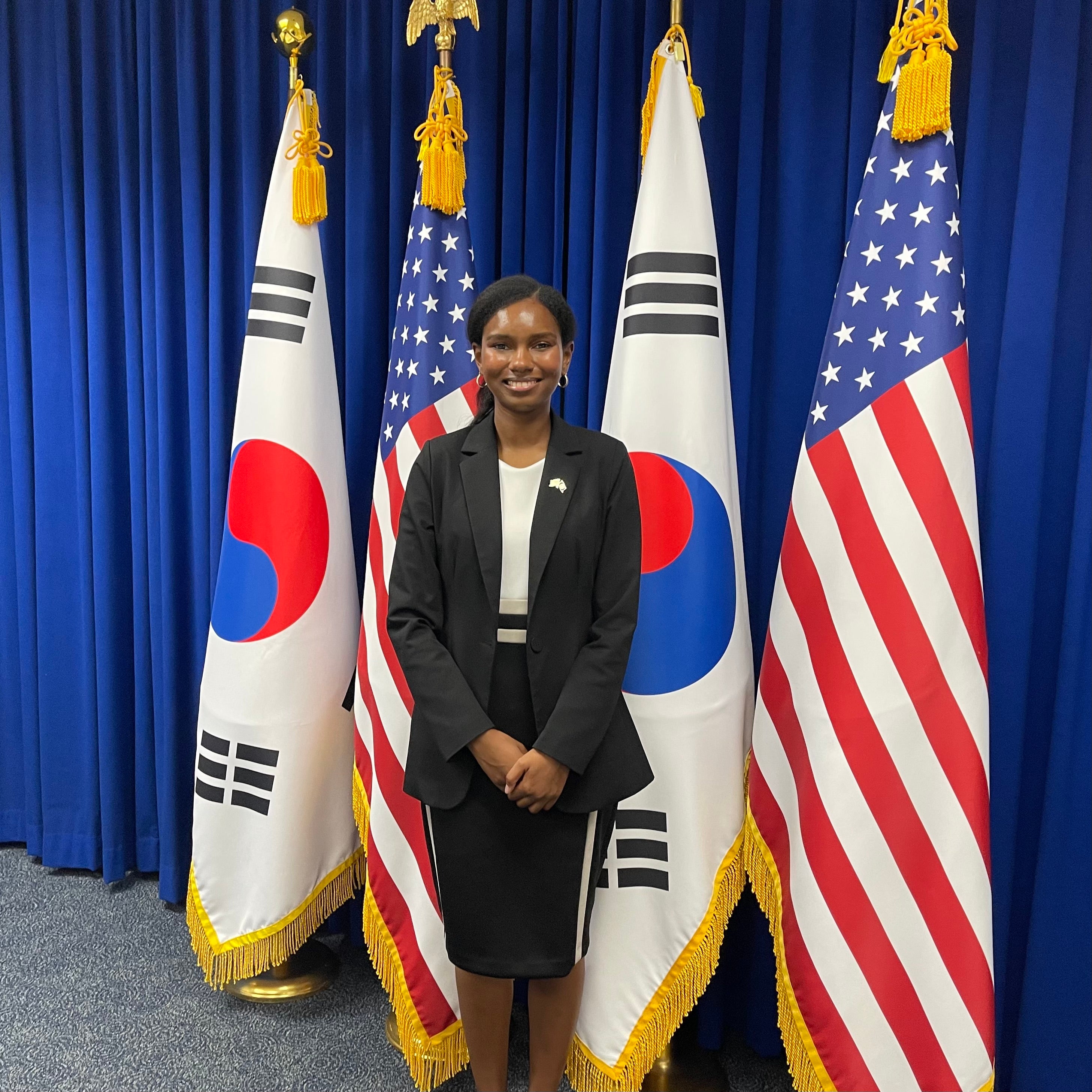 Salamata Bah stands in front of South Korean and U.S. flags at the U.S. Embassy in Seoul, South Korea.