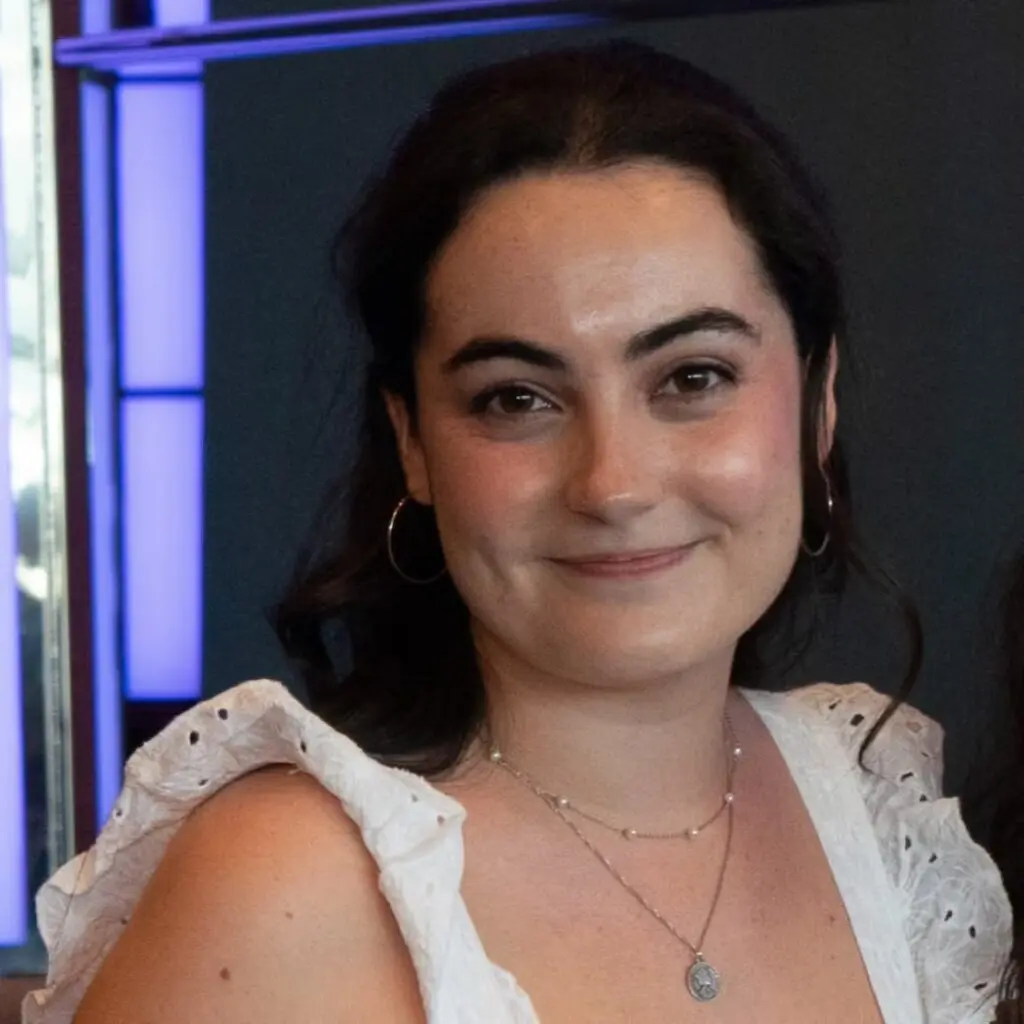 Scarlett Watkins wearing a white lace blouse and a necklace.
