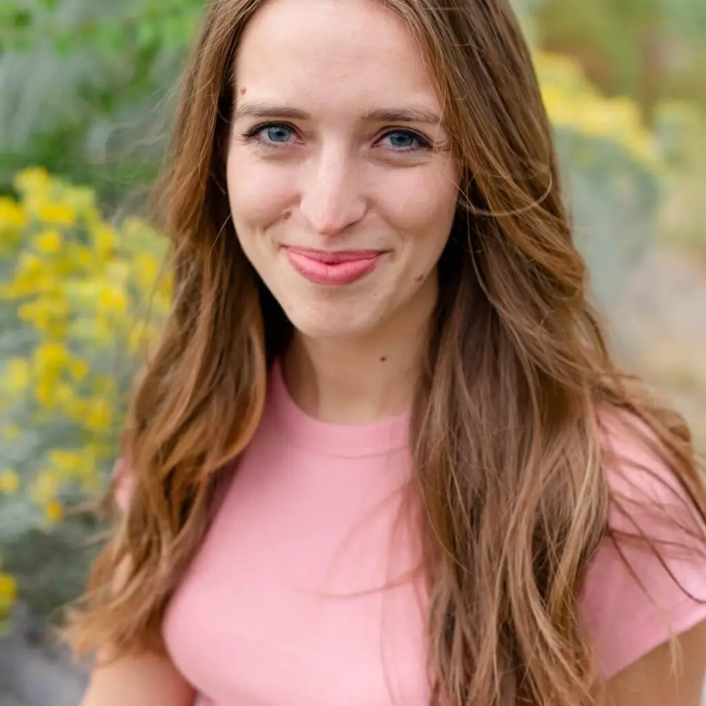 Shelby Jo Huey wearing a pink shirt against the background of flowers.