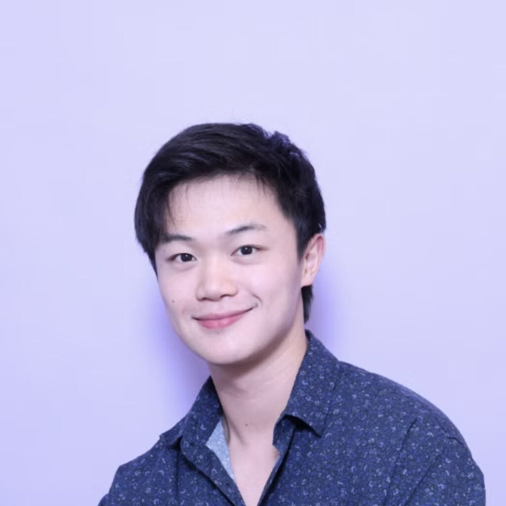 Shung Shawn Yue Liu wearing a blue button down shirt with a floral pattern.